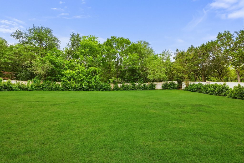 7609 Sandia Loop Austin, TX 78735 - Photo 37 of 40 The sprawling, level lawn offers a vast green space for recreation, fully enclosed by perimeter fencing and a natural screen of trees for total privacy and tranquility.