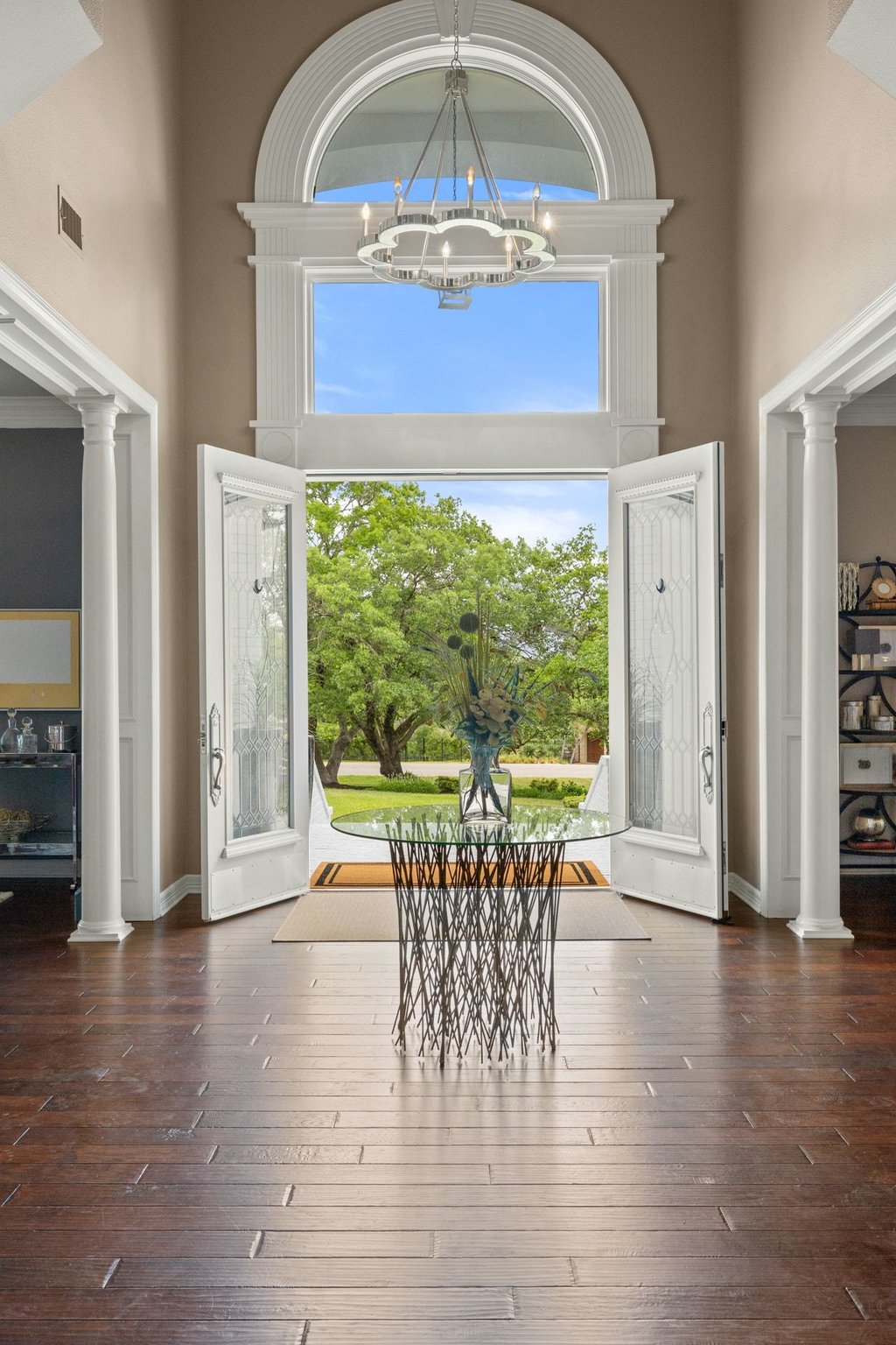 7609 Sandia Loop Austin, TX 78735 - Photo 7 of 40 The grand foyer makes a lasting impression with towering ceilings, rich hardwood floors, and a massive arched window