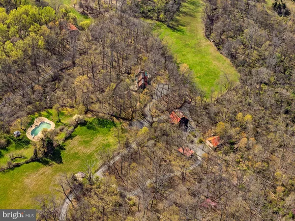 an aerial view of residential houses with outdoor space and trees