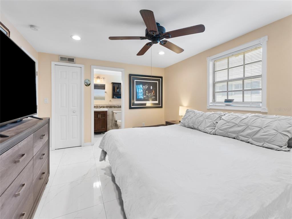 4237 Redcliff Place New Port Richey, FL 34652 - Photo 17 of 25 a bedroom with a large bed and a flat screen tv