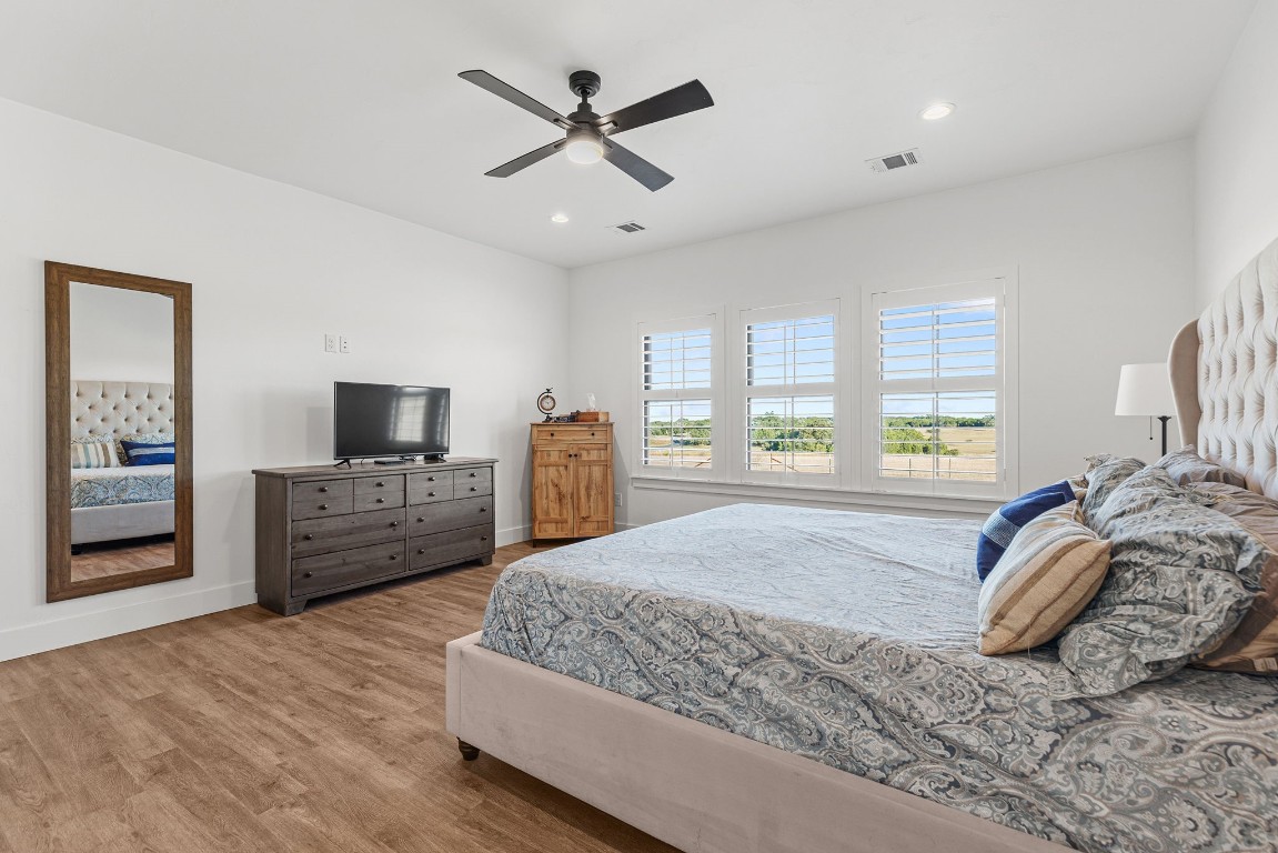 345 Judge's Road Burnet, TX 78611 - Photo 18 of 40 a spacious bedroom with a large bed a flat tv screen and a dresser