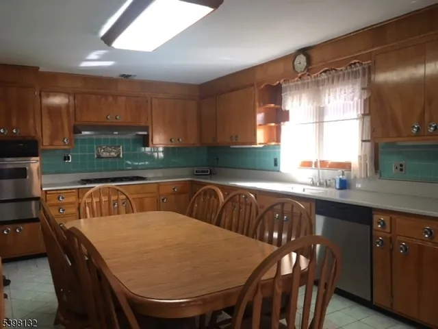 a kitchen with a table chairs sink and cabinets