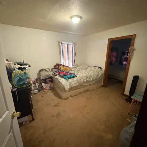 a spacious bedroom with a bed and a chair