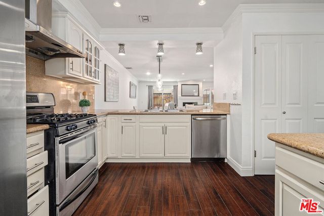 a kitchen with stainless steel appliances a white stove top oven sink and cabinets