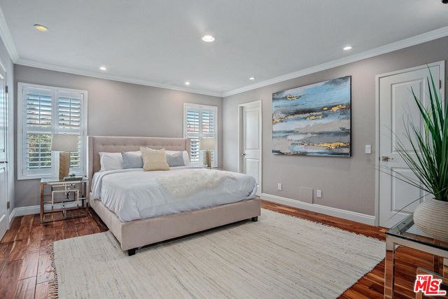 a bedroom with a large bed and a flat screen tv