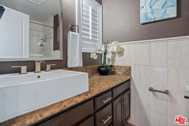 a spacious bathroom with a granite countertop sink a mirror and vanity