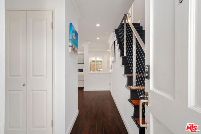 a view of hallway with stairs and wooden floor