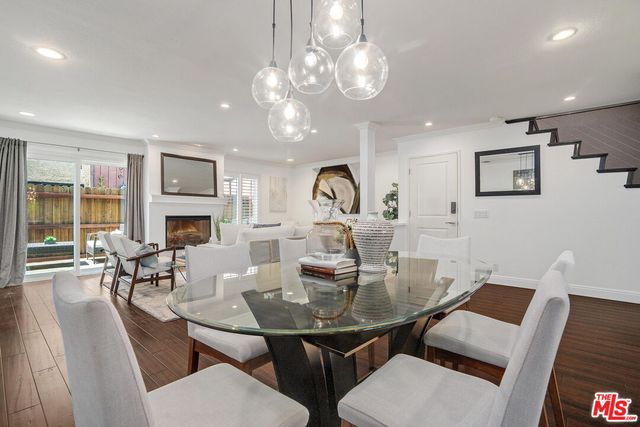 a view of a dining room with furniture a chandelier and wooden floor