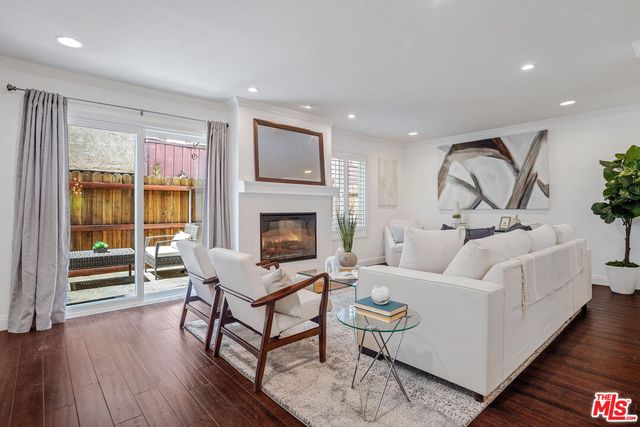 a living room with furniture a fireplace and wooden floor