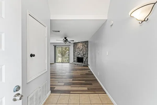 a view of an empty room with a fireplace and a window
