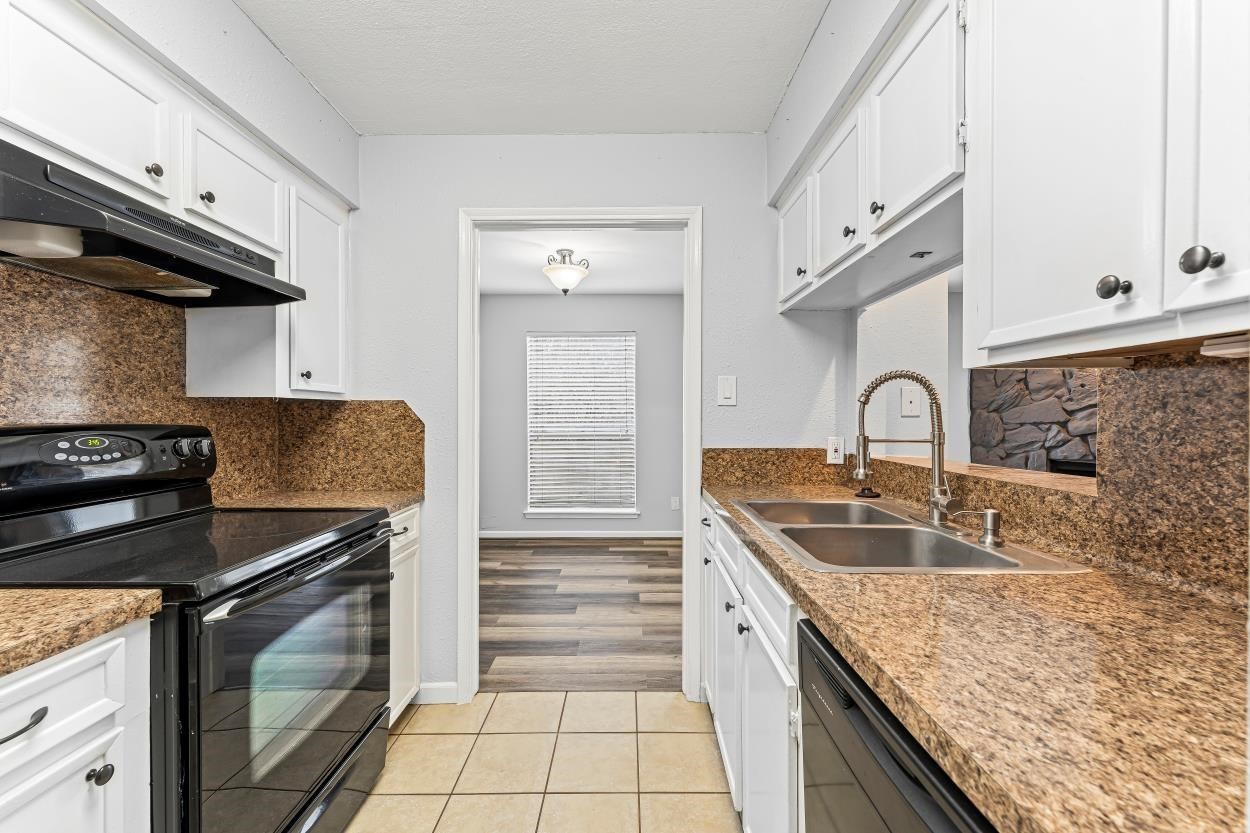 19 Hideaway Drive Friendswood, TX 77546 - Photo 7 of 11 a kitchen with granite countertop a sink stove and cabinets