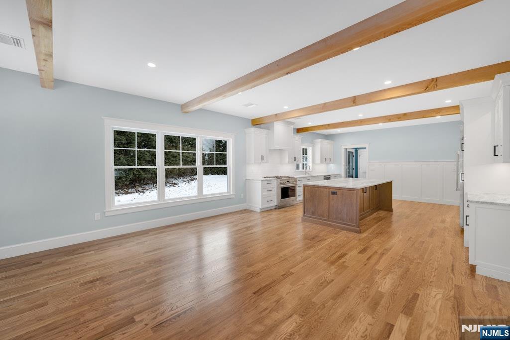 28 North Street Ramsey, NJ 07446 - Photo 13 of 50 a large white kitchen with wooden floors and wide window
