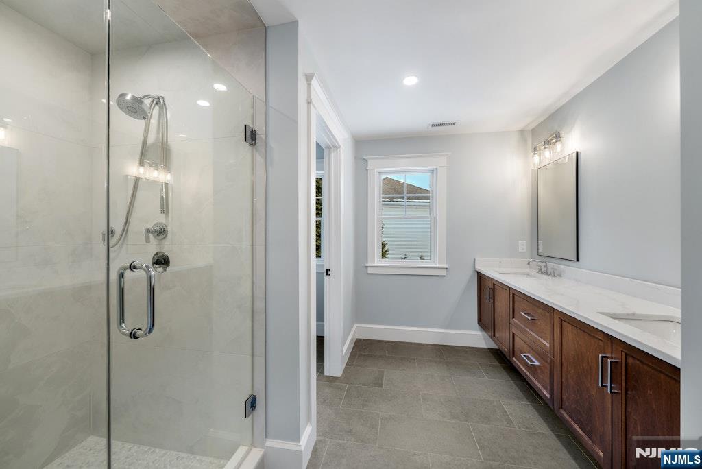28 North Street Ramsey, NJ 07446 - Photo 28 of 50 a bathroom with a double vanity sink a large mirror and shower