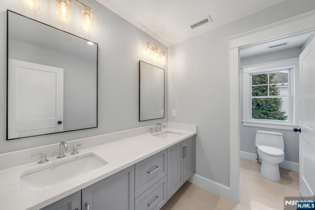 28 North Street Ramsey, NJ 07446 - Photo 37 of 50 a bathroom with a double vanity sink toilet and a mirror