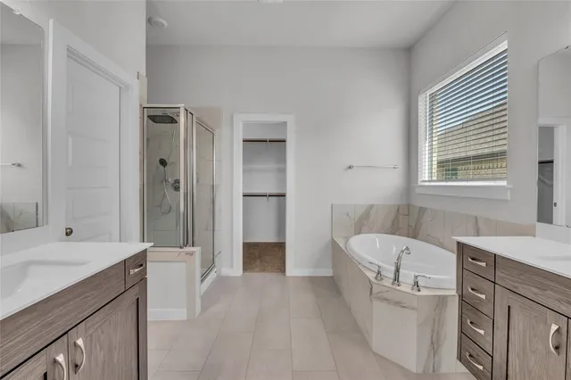 a spacious bathroom with a tub sink shower and mirror