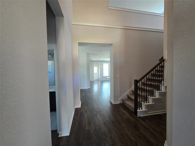 a view of a hallway with wooden floor and staircase