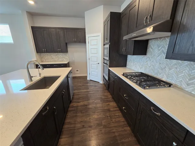 a kitchen with wooden cabinets and a stove top oven