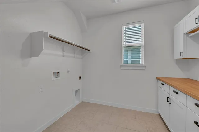 a view of a kitchen with white cabinets and a window