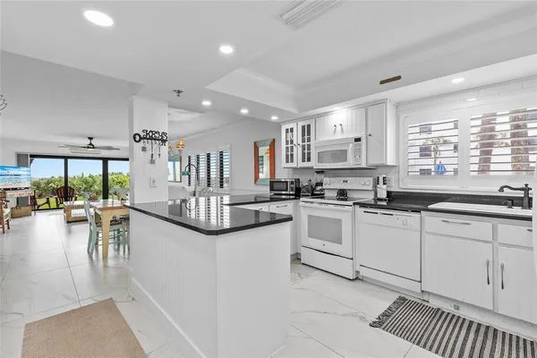 a kitchen with white cabinets sink and stove