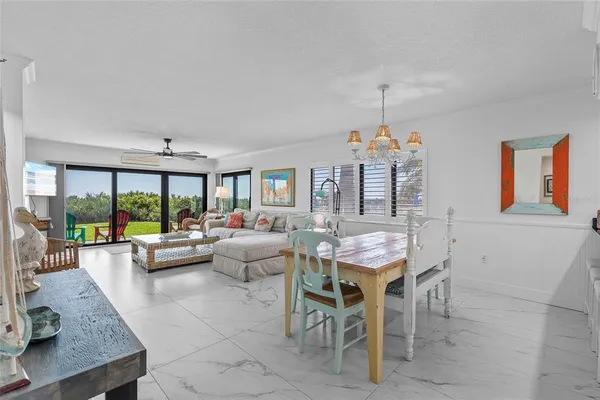 a living room with furniture two large windows and a chandelier