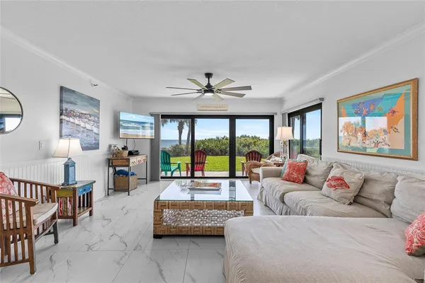 a living room with furniture and a large window with balcony view