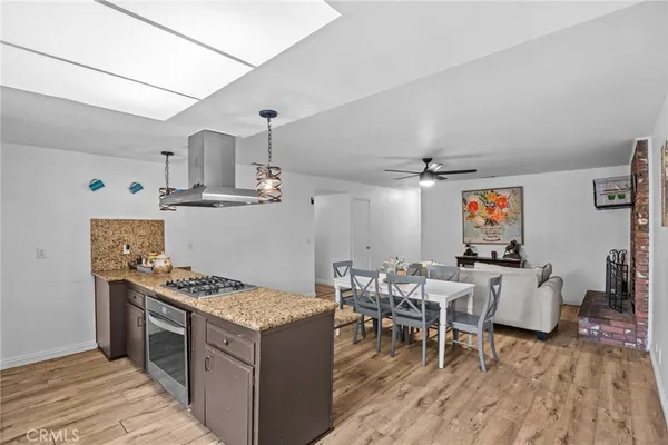 a open kitchen with stainless steel appliances granite countertop a stove and a wooden floors
