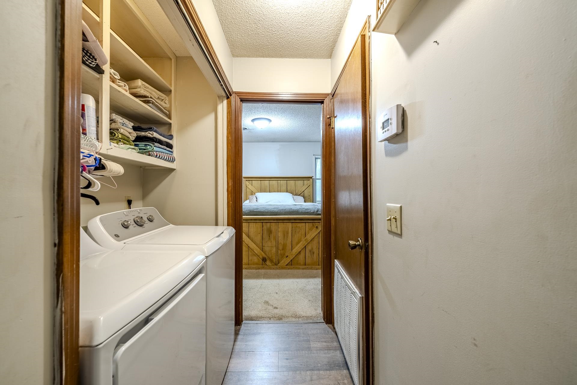 259 Oakview Drive Adamsville, TN 38310 - Photo 17 of 32 Dedicated laundry area featuring built-in shelving, a white washer and dryer set, and wood-finish door frames
