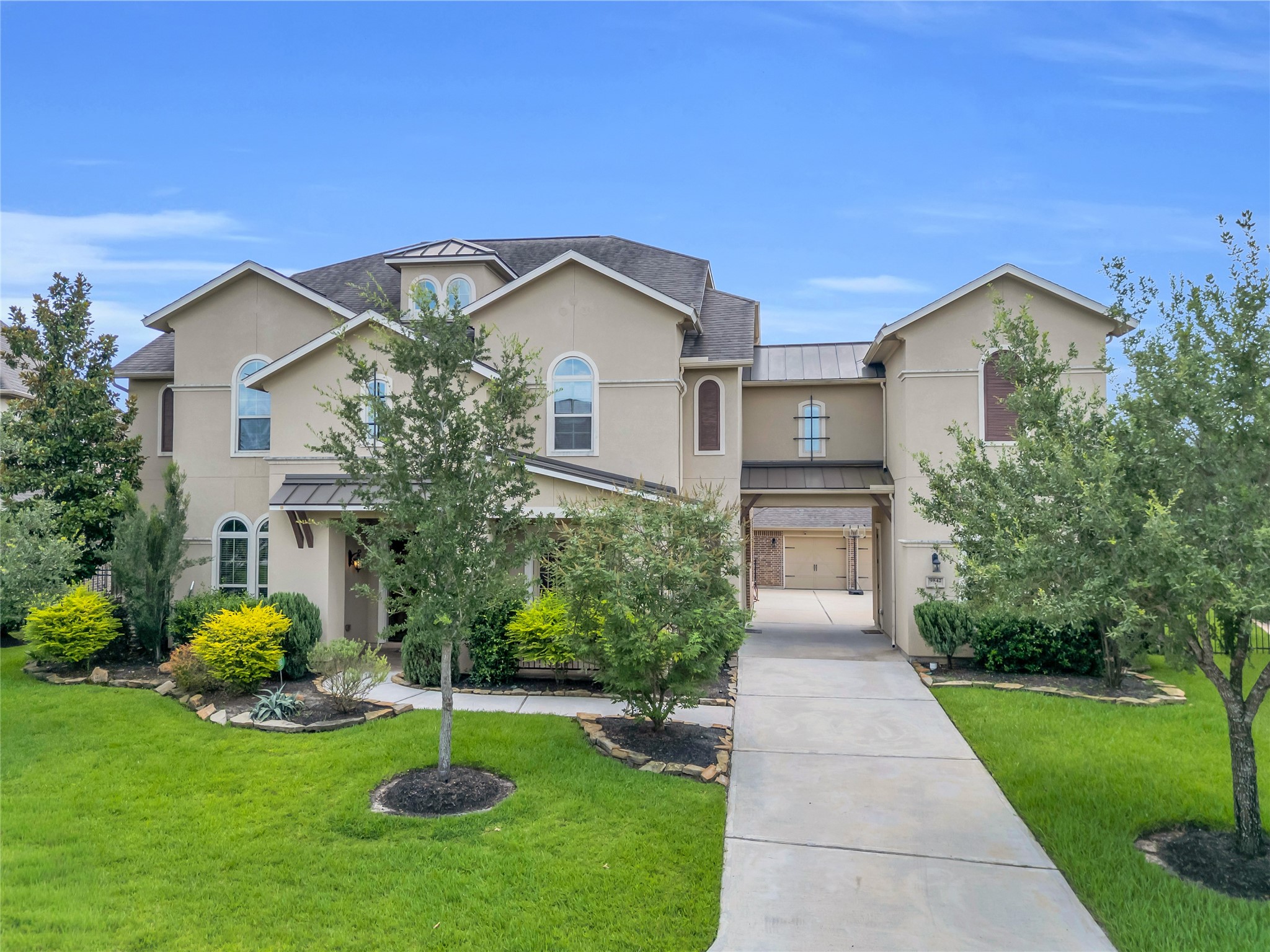 9842 Kirkstone Terrace Drive Spring, TX 77379 - Photo 2 of 34 Elegant two-story home featuring large windows and a well-maintained front yard with lush greenery. The property includes a long driveway leading to a 4 car spacious garage.