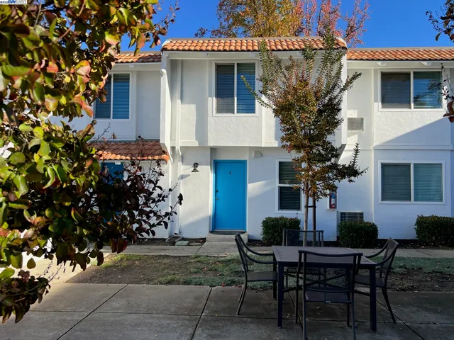 a view of a house with a yard and sitting area