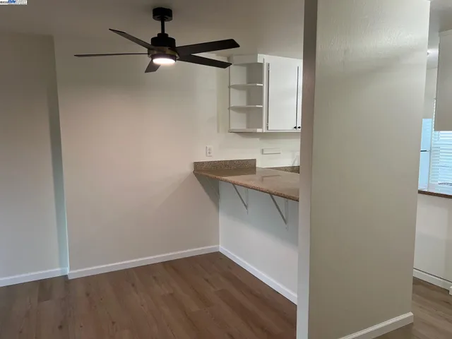 a view of an empty room with wooden floor and a cabinet