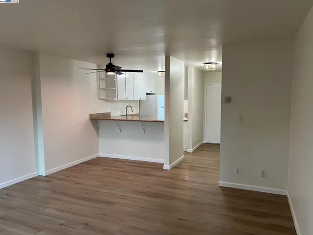 wooden floor in an empty room with a kitchen