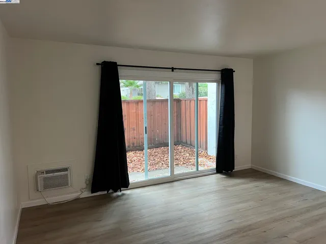 an empty room with wooden floor and door