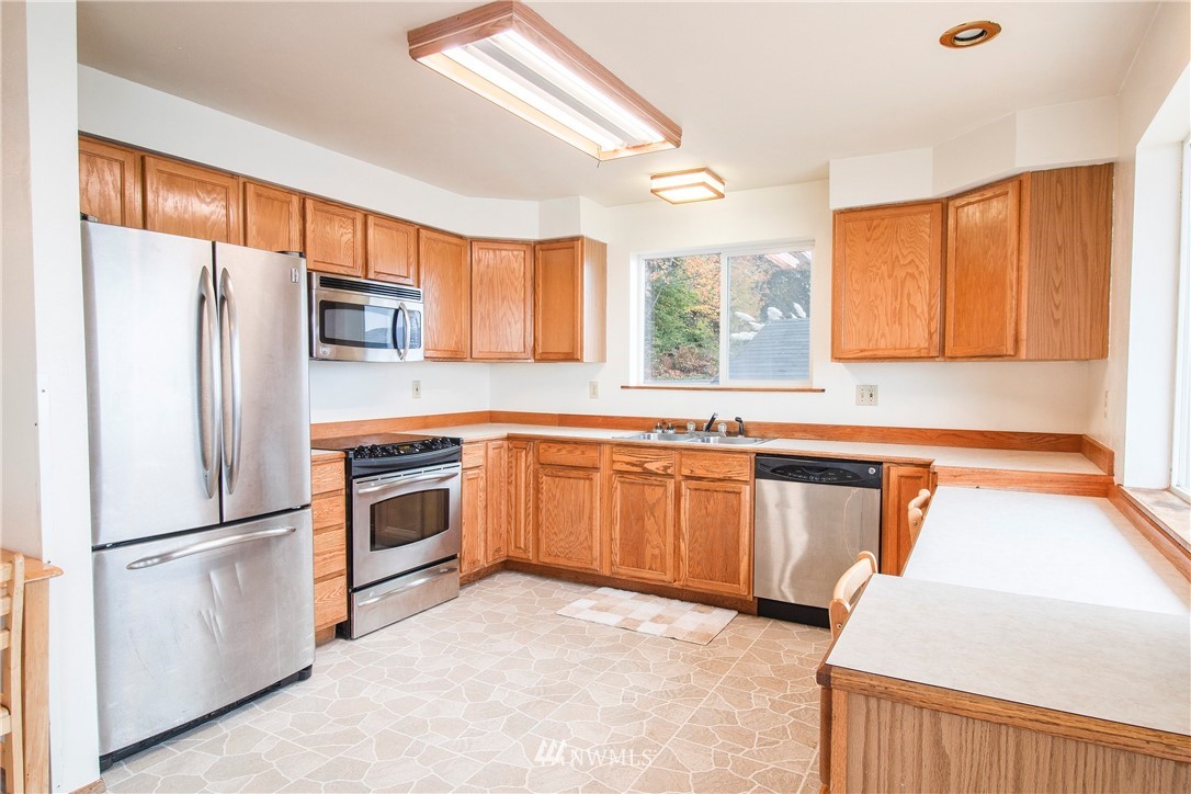7971 Northeast North Shore Road Belfair, WA 98528 - Photo 12 of 25 a kitchen with granite countertop stainless steel appliances a refrigerator a sink and cabinets