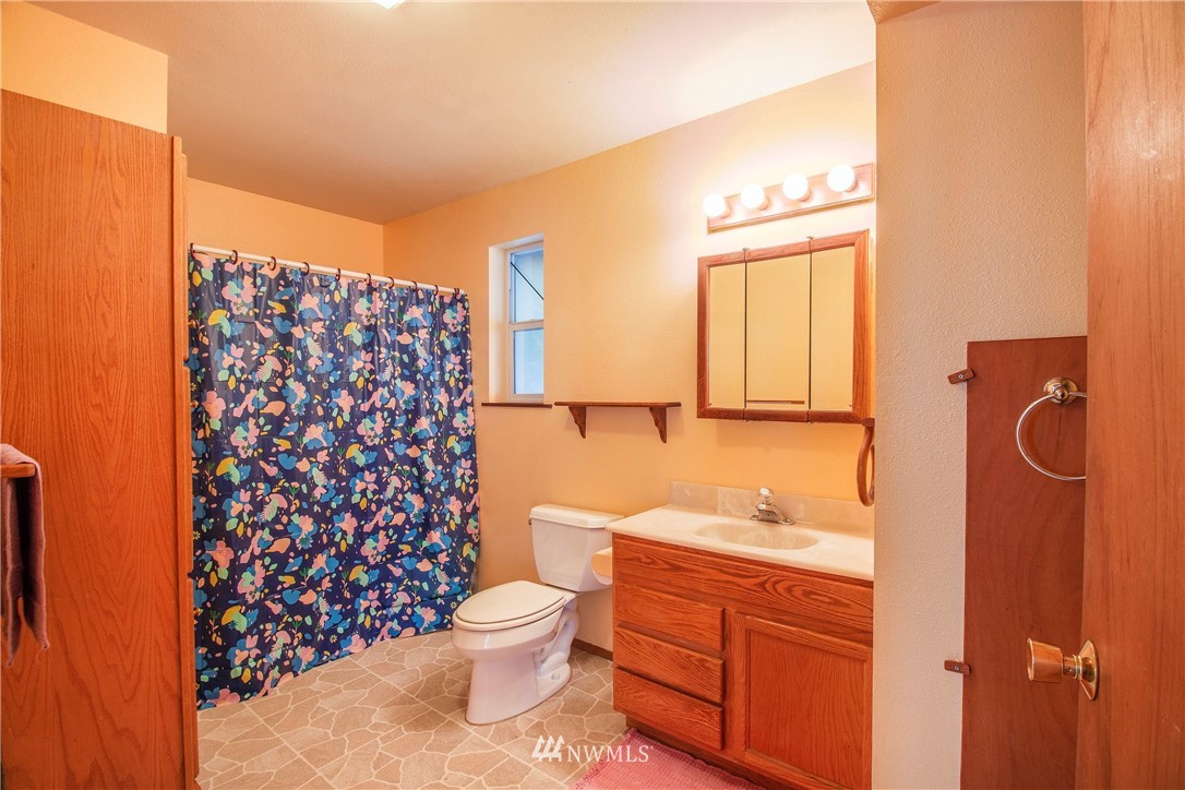 7971 Northeast North Shore Road Belfair, WA 98528 - Photo 16 of 25 a bathroom with a granite countertop toilet sink and a shower