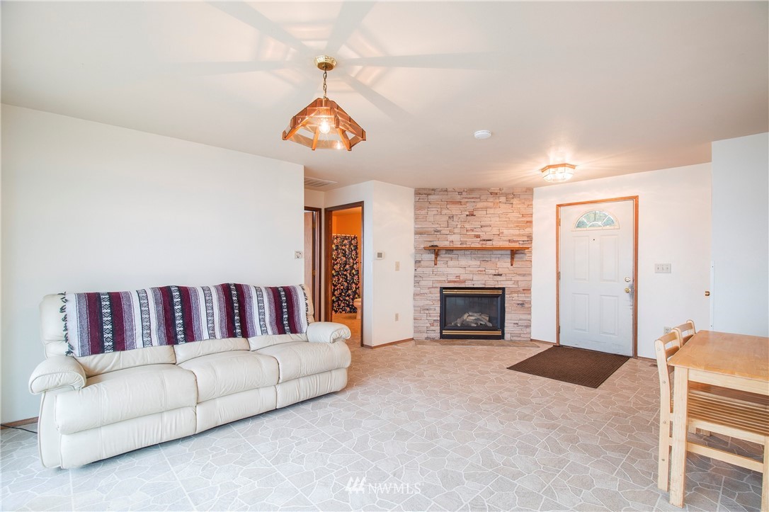 7971 Northeast North Shore Road Belfair, WA 98528 - Photo 7 of 25 a living room with furniture a fireplace and a chandelier