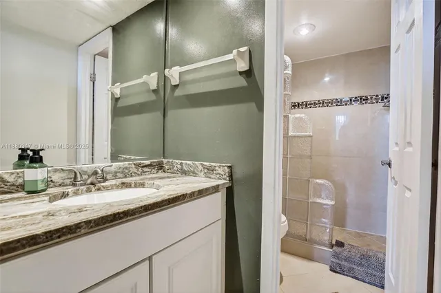a bathroom with a shower sink and mirror