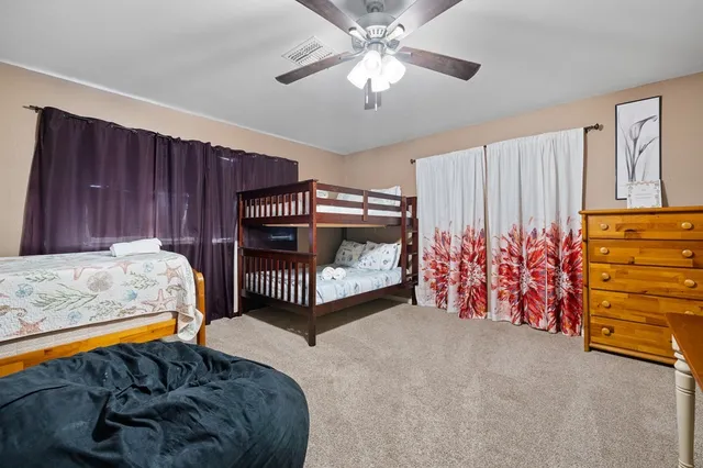 a bed room with a bed and a ceiling fan
