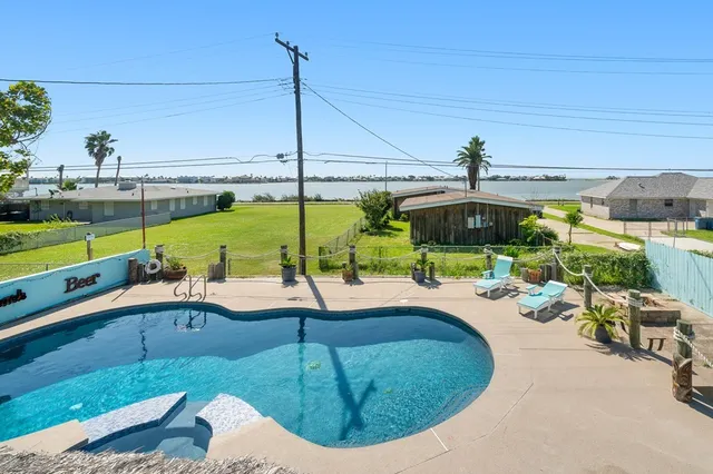 a swimming pool with outdoor seating and yard