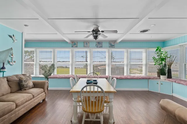 a living room with furniture a flat screen tv and a large window