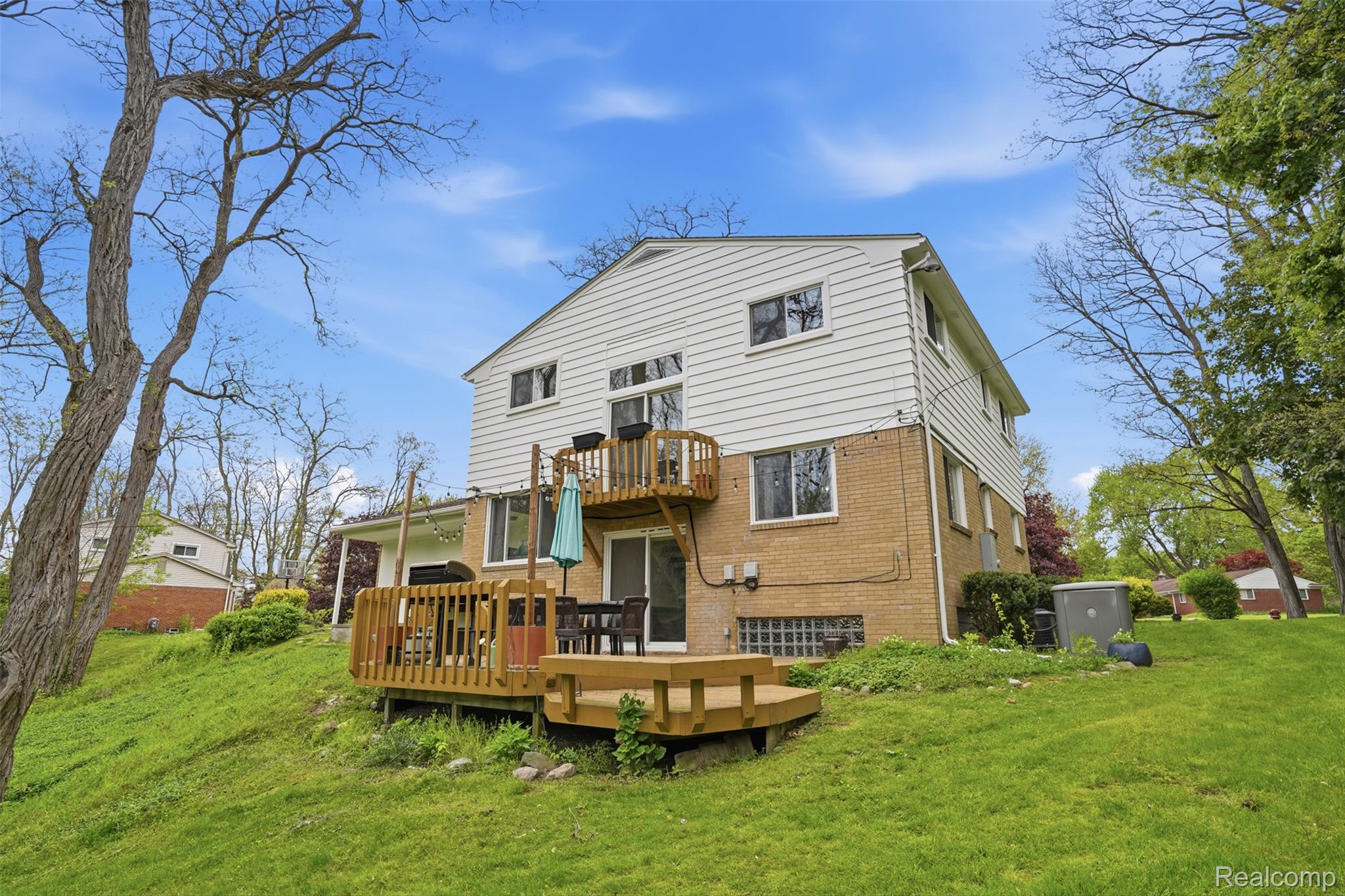 47129 Dunsany Road Northville, MI 48167 - Photo 35 of 49 Rear view of house featuring a lawn, a deck, and brick siding