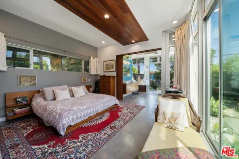 a bedroom with furniture and large windows