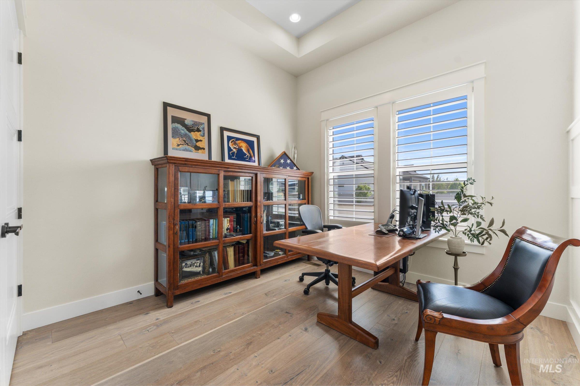 6585 South Pemberley Way Meridian, ID 83642 - Photo 29 of 43 Room featuring wood-finish flooring, light-toned walls, and a tray ceiling