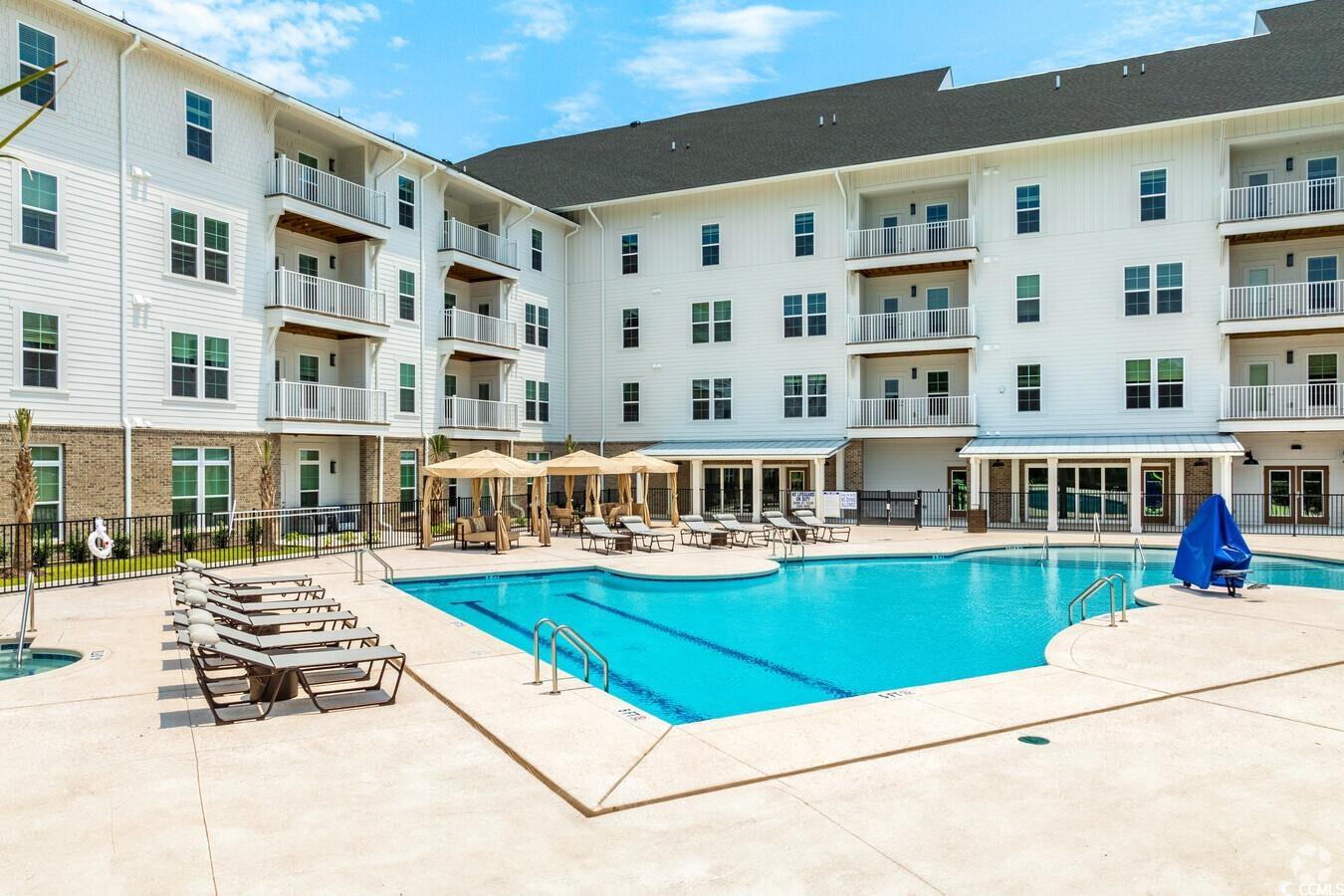 147 Laurenco Loop, Unit JADE Myrtle Beach, SC 29579 - Photo 1 of 40 Community pool with fence and a patio area