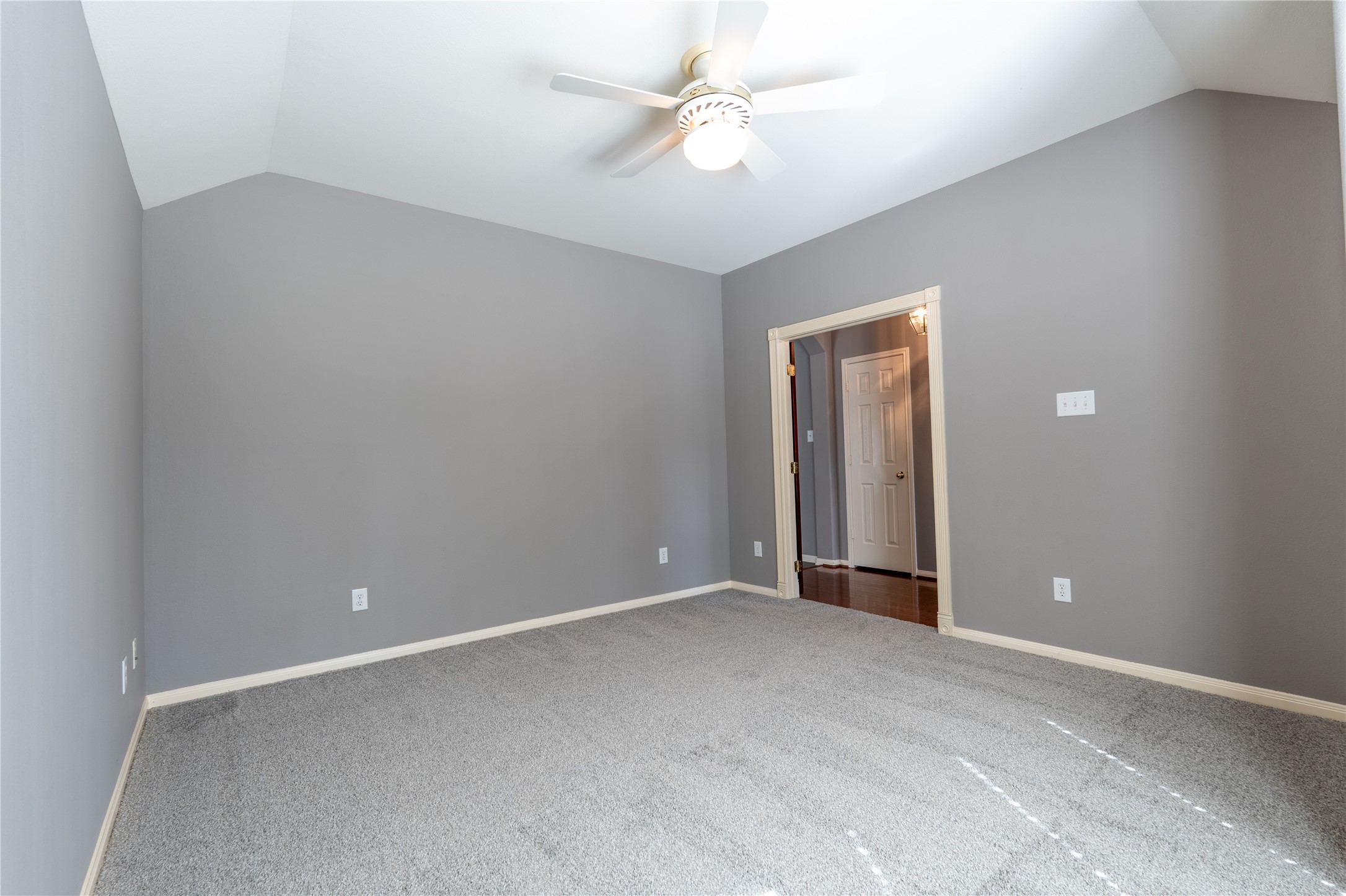 10619 Crownsedge Drive Spring, TX 77379 - Photo 12 of 38 The office space/flex bedroom features a neutral grey color palette with plush carpeting, a vaulted ceiling, and a ceiling fan. It offers a spacious feel with an open doorway leading to the entry hallway.