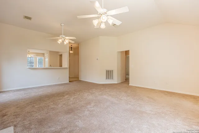 an empty room with windows and fireplace