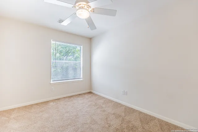 an empty room with a chandelier fan
