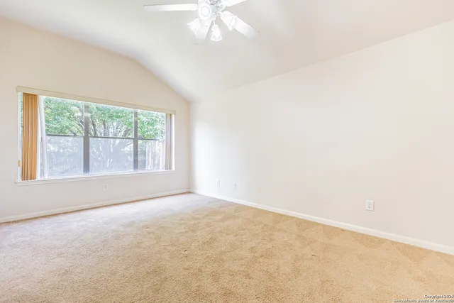 a view of an empty room with a chandelier fan