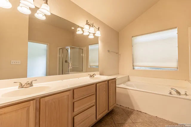 a bathroom with a bathtub a shower and a sink