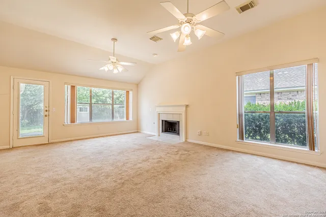 a view of an empty room with window and fireplace