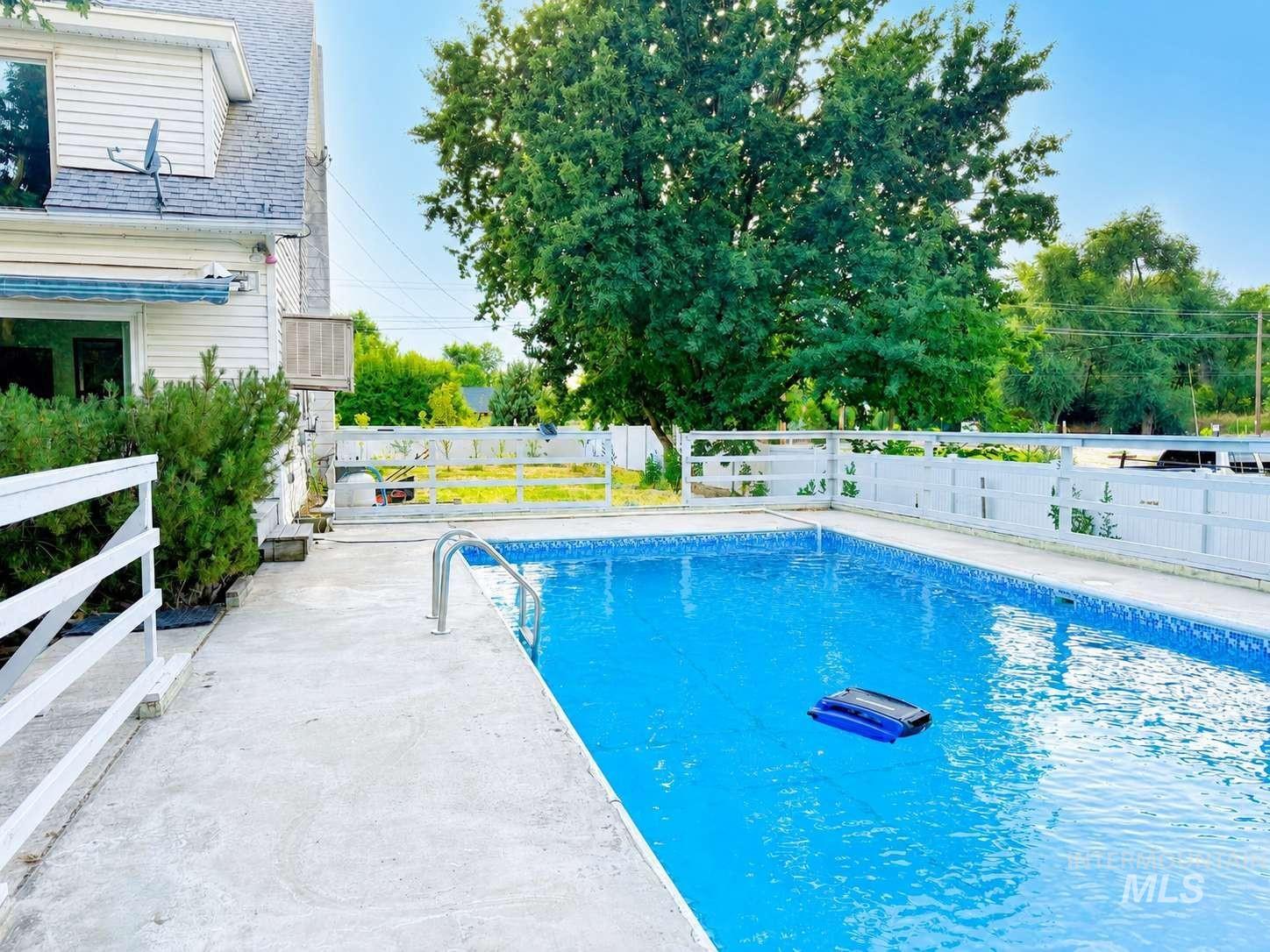 1158 South Powerline Road Nampa, ID 83686 - Photo 4 of 46 In-ground pool featuring a concrete surround and white perimeter fencing